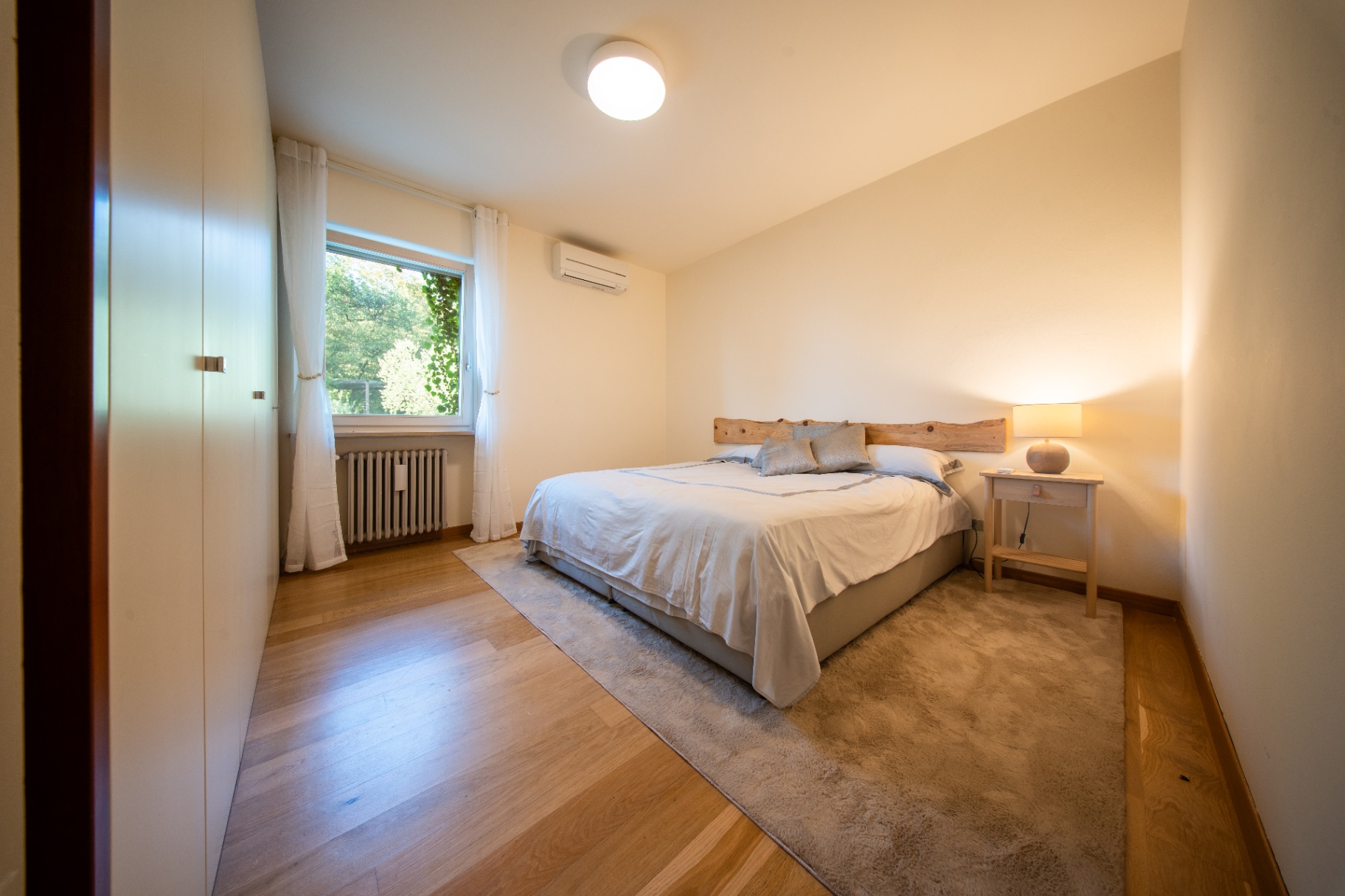 Warm double bedroom with live-edge wooden headboard