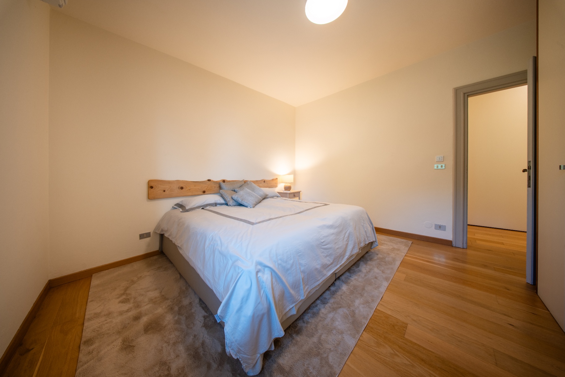 Warm-lit double bedroom with live-edge headboard