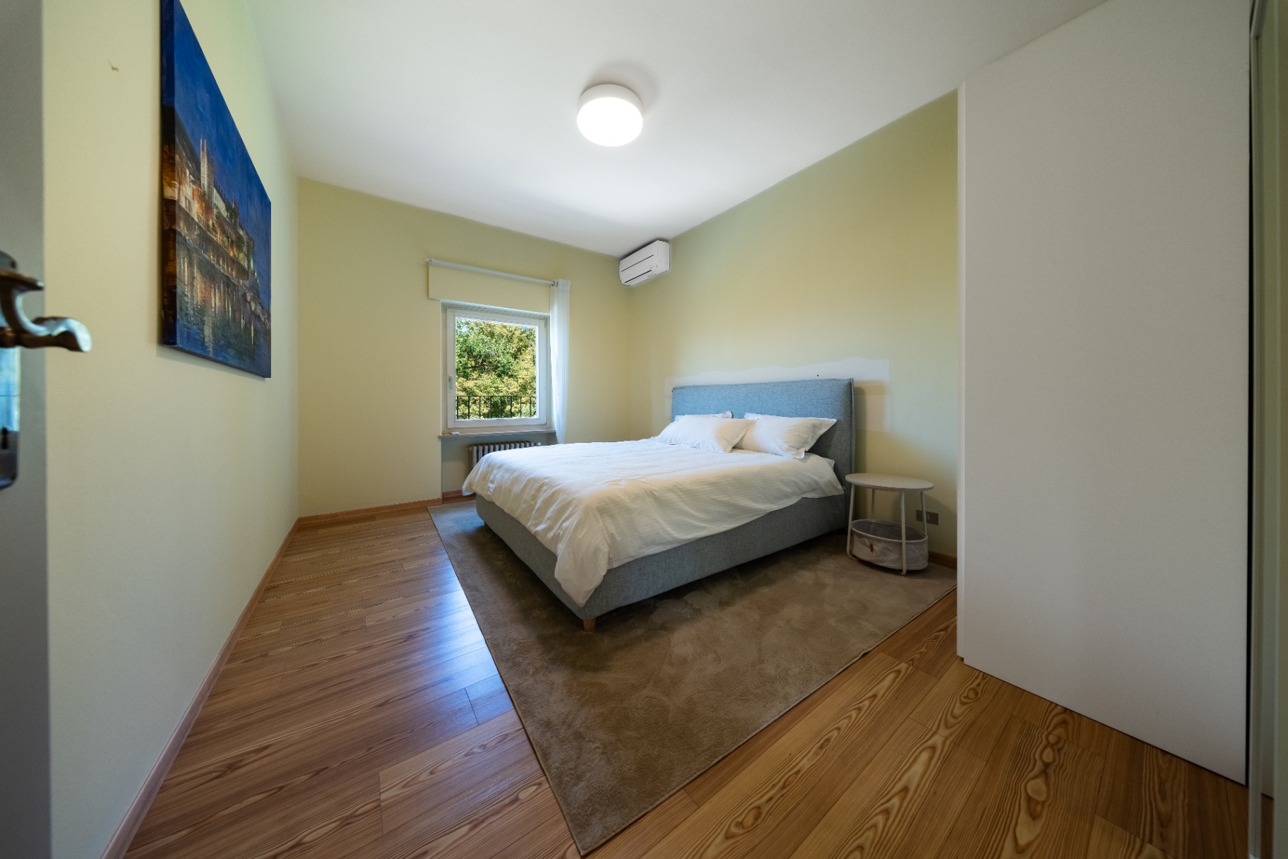 Green-toned double bedroom with garden-view window