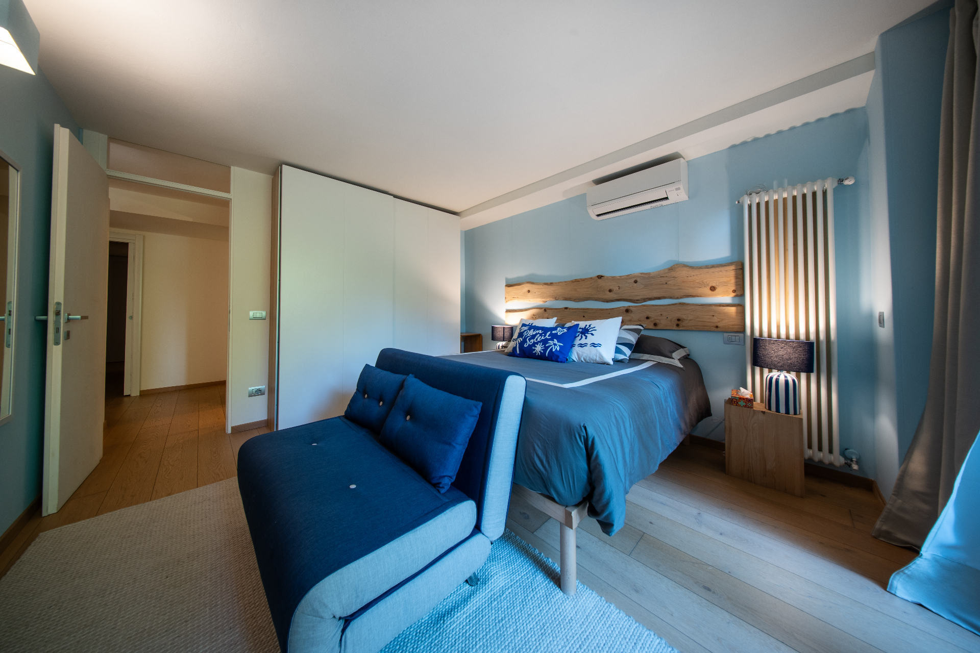Blue double bedroom with live-edge headboard and blue chaise