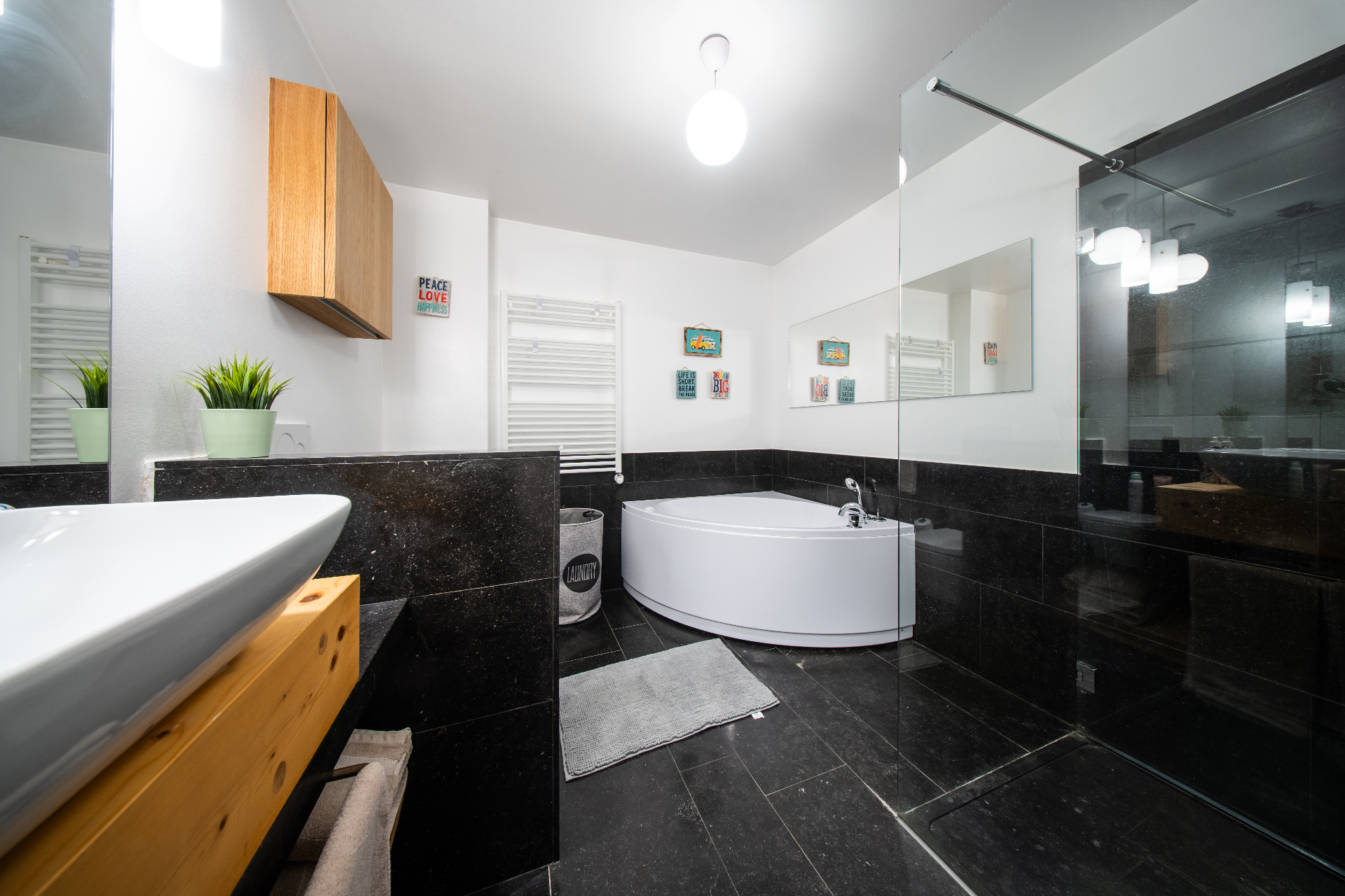 Master bathroom with black stone tiles and corner tub