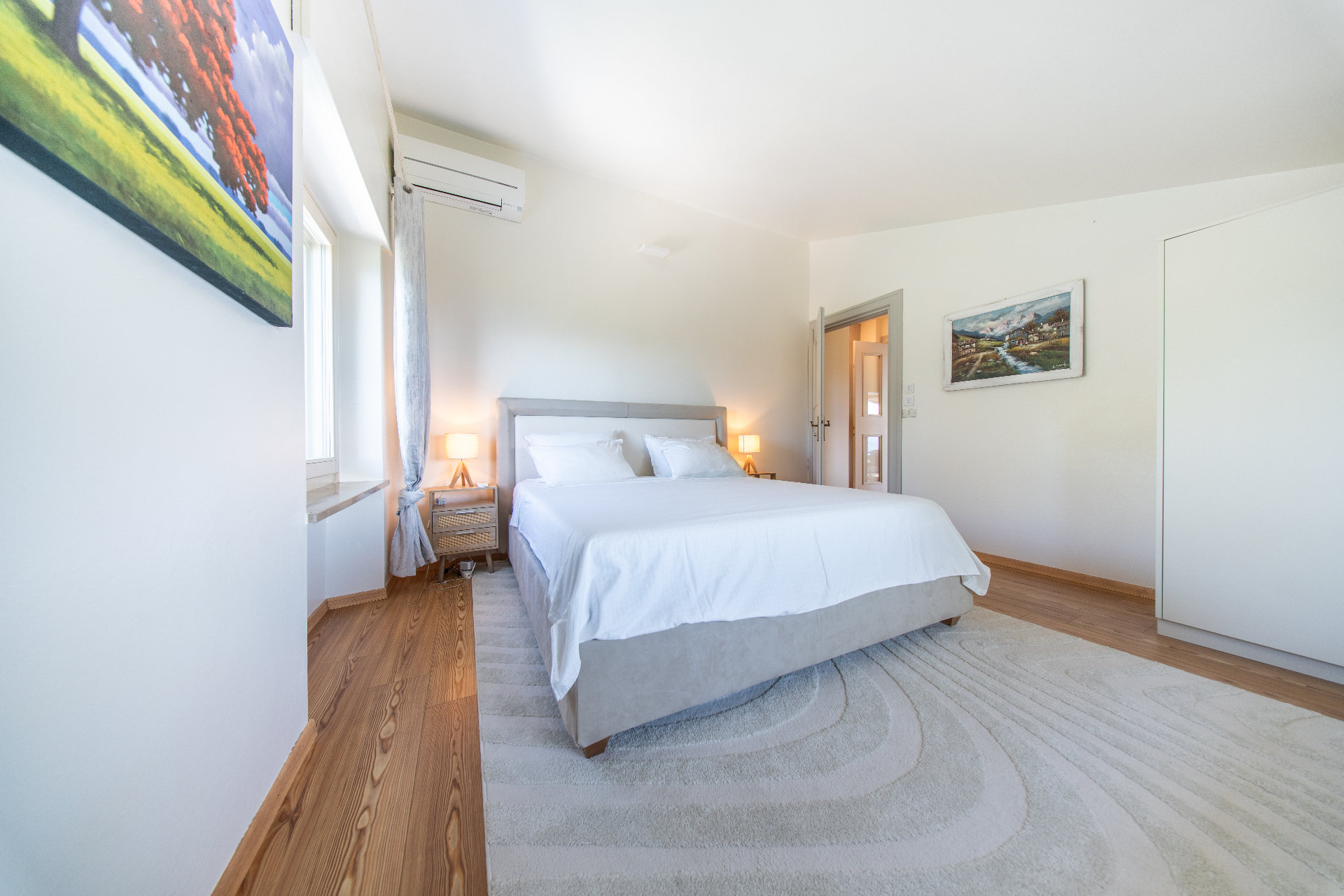 King bedroom with artwork and soft neutral tones