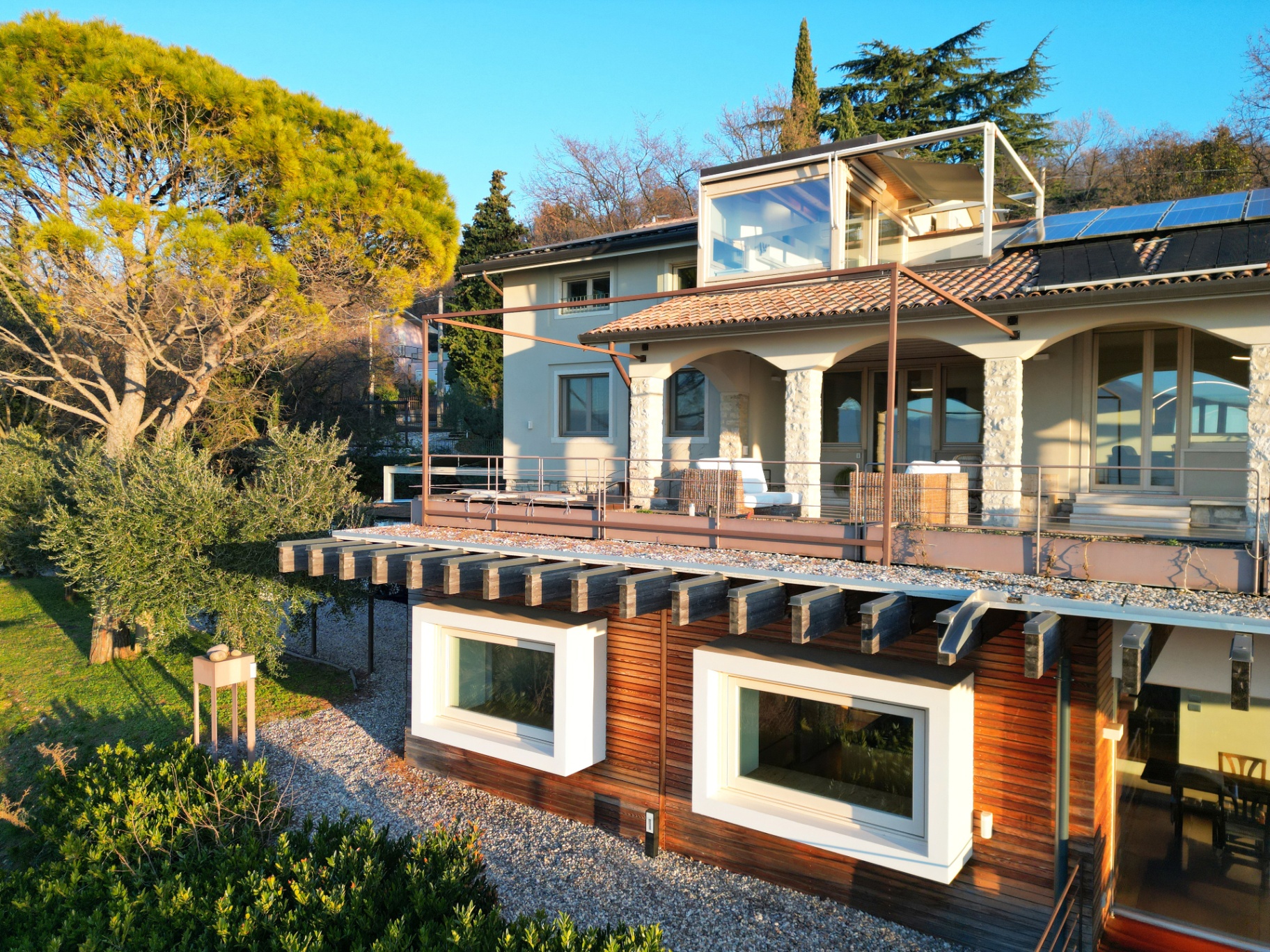 Villa exterior in golden hour with pergola and penthouse office
