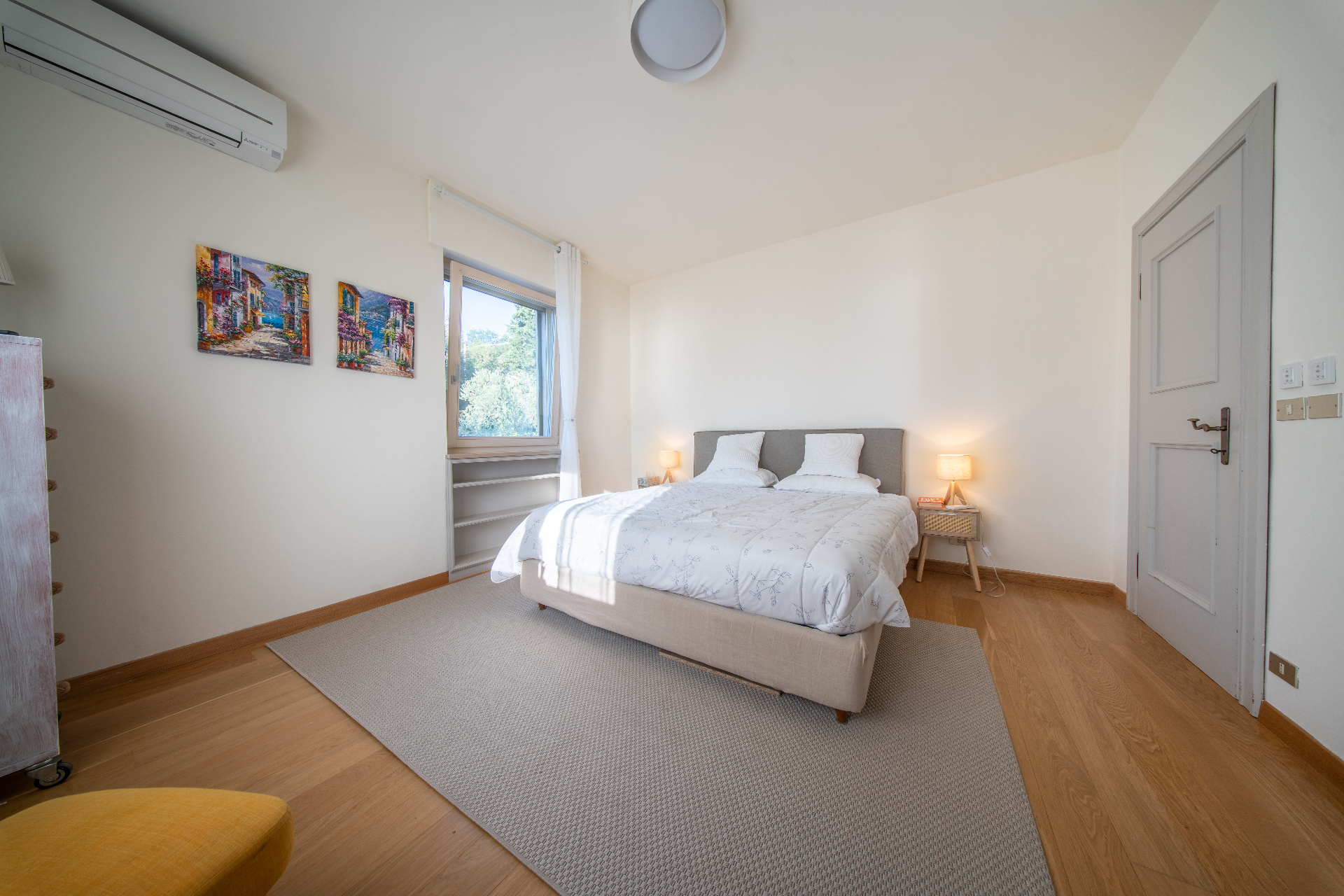Double bedroom with Mediterranean street artwork and garden window